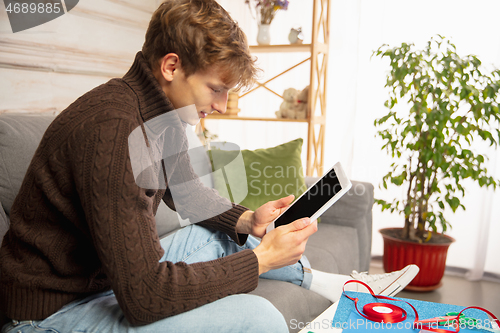 Image of Man reading message, greetings for New Year and Christmas 2021 from friends or family with his tablet