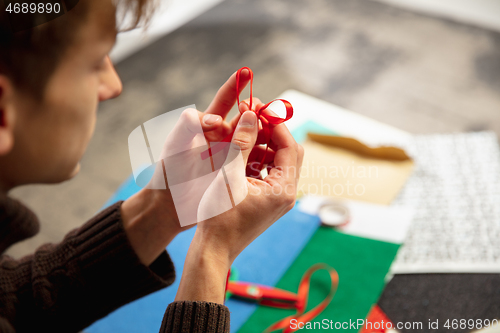 Image of Man making greeting card for New Year and Christmas 2021 for friends or family, scrap booking, DIY