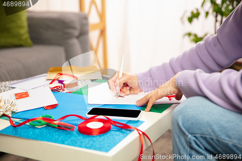 Image of Woman making greeting card for New Year and Christmas 2021 for friends or family, scrap booking, DIY