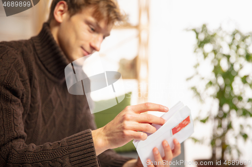 Image of Man opening, recieving greeting card for New Year and Christmas 2021 from friends or family