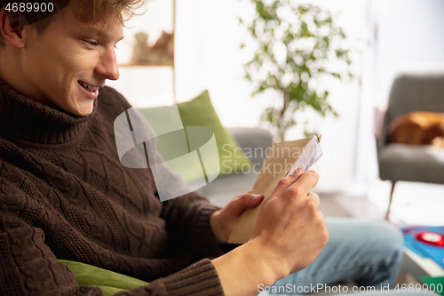 Image of Man opening, recieving greeting card for New Year and Christmas 2021 from friends or family