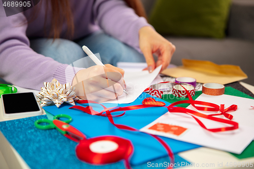 Image of Woman making greeting card for New Year and Christmas 2021 for friends or family, scrap booking, DIY