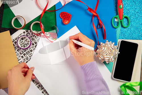 Image of Woman making greeting card for New Year and Christmas 2021 for friends or family, scrap booking, DIY