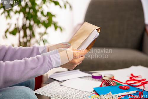 Image of Woman opening, recieving greeting card for New Year and Christmas 2021 from friends or family