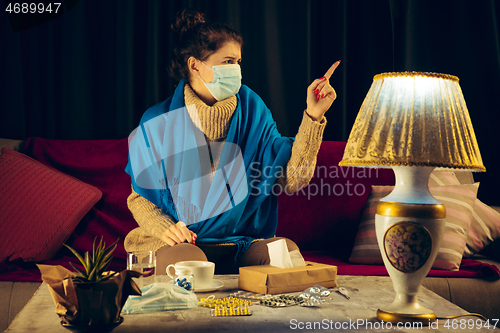 Image of Woman wrapped in a plaid wearing face mask trying to protect from somebody\'s sick