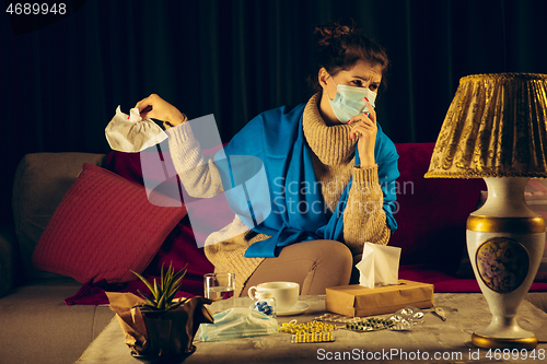 Image of Woman wrapped in a plaid wearing face mask trying to protect from somebody\'s sick