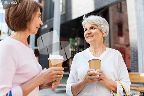 Image of senior women with shopping bags and coffee in city