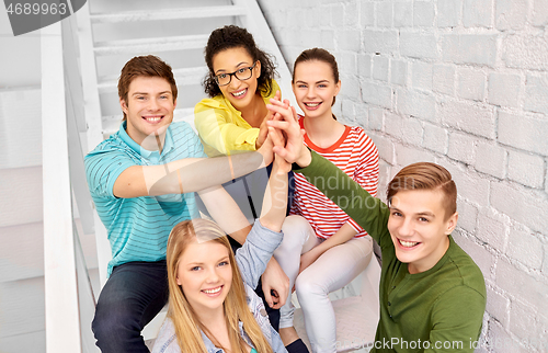 Image of teenage friends or students making high five