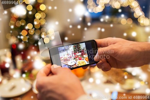 Image of hands photographing food at christmas dinner