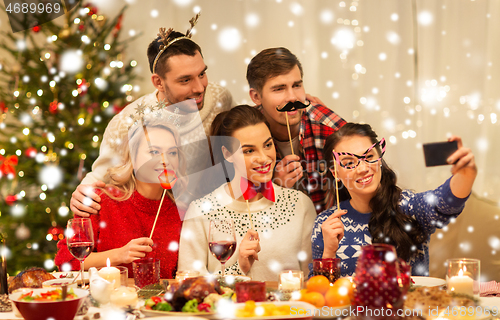 Image of friends taking selfie at christmas dinner