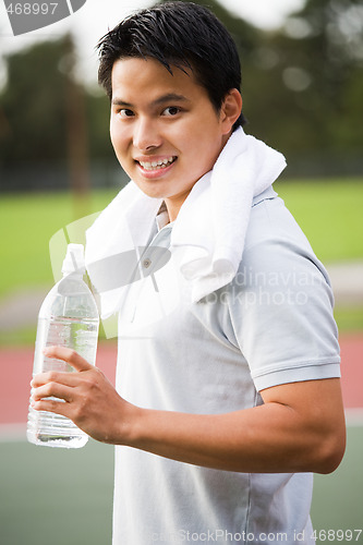 Image of Asian male holding water bottle