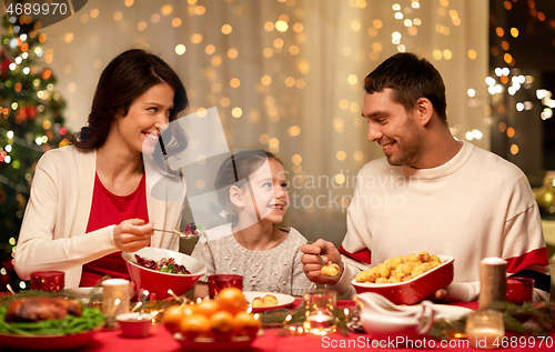 Image of happy family having christmas dinner at home