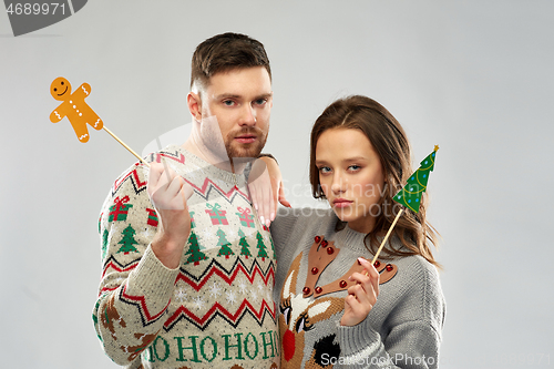 Image of couple with christmas party props in ugly sweaters