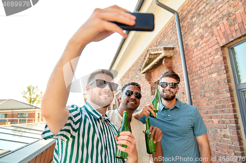 Image of men drinking beer and taking selfie by smartphone