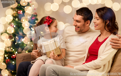 Image of happy family with christmas present at home