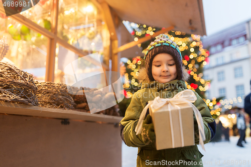 Image of happy boy with gift box at christmas market