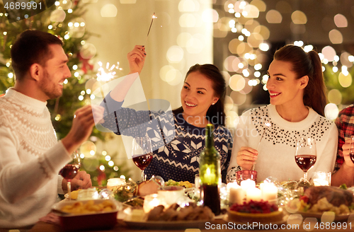 Image of happy friends celebrating christmas at home feast