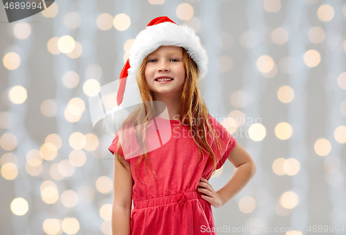 Image of smiling red haired girl posing in santa helper hat