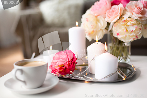 Image of coffee, candles, garland and flowers on table