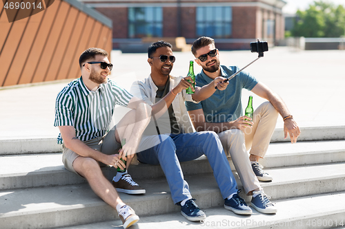 Image of men toasting beer and taking selfie by smartphone