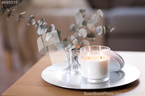 Image of burning fragrance candle on table at cozy home