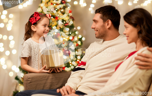 Image of happy family with christmas present at home