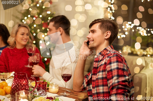 Image of man calling on smartphone at christmas dinner
