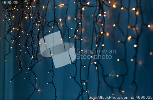 Image of christmas garland lights over dark blue background