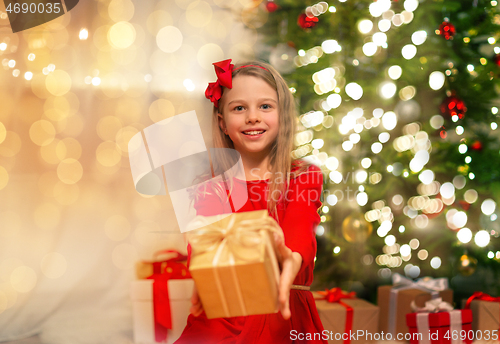 Image of smiling girl with christmas gift at home