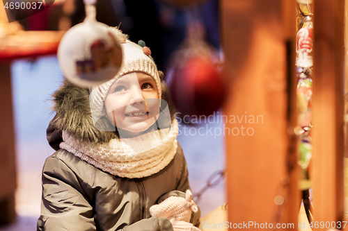 Image of happy little girl at christmas market in winter