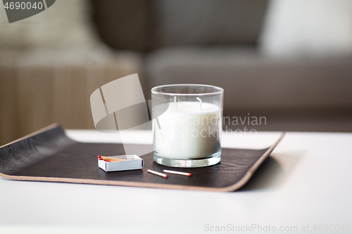 Image of fragrance candle and matches on tray on table