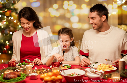 Image of happy family having christmas dinner at home