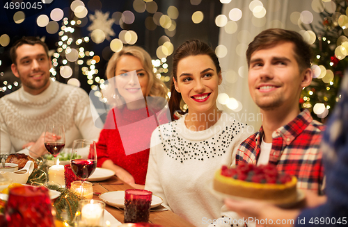 Image of happy friends having christmas dinner at home