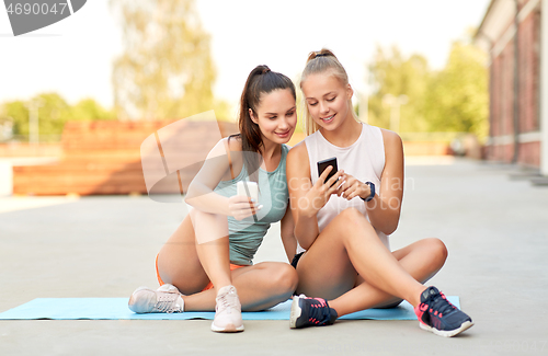 Image of sporty women or friends with smartphone on rooftop