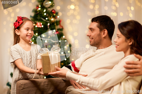 Image of happy family with christmas present at home