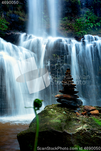 Image of Zen waterfall with lush foliage and balancing stones