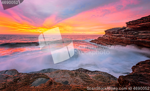 Image of Sunrise sun rays light up the sky and reflect in the ocean and r