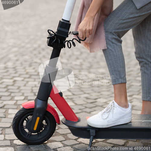 Image of User unlocking rental electric scooter. Eco friendly green modern urban mobility concept of sharing transportation with electric scooters for rent in Ljubljana, Slovenia