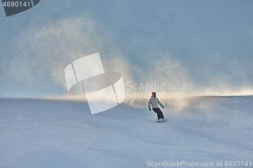 Image of Female snowboarder fast on a slope