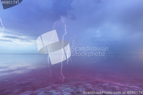 Image of Thunderstorm over the pink lake with extremely salted water.