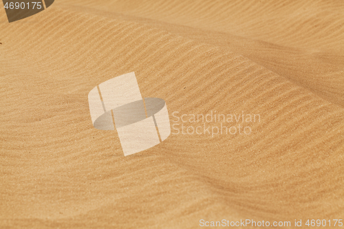 Image of Yellow desert sand with diagonal wave patern.
