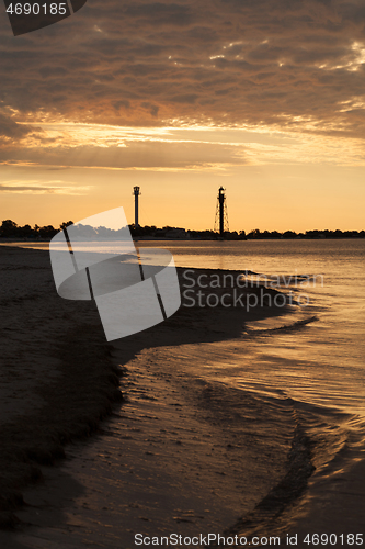 Image of Two lighthouses on the island near sea at sunset