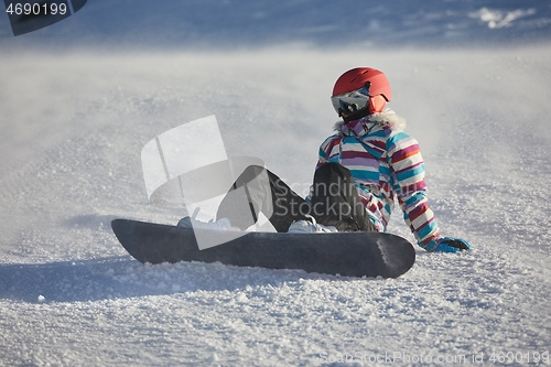 Image of Snowboarder sitting in the snlow