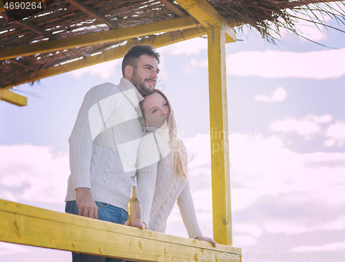 Image of young couple drinking beer together at the beach