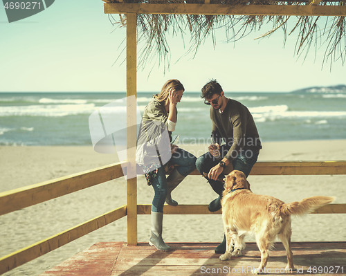 Image of young couple with a dog at the beach