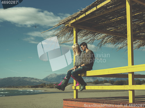 Image of young couple drinking beer together at the beach