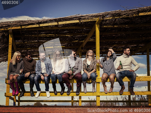 Image of Group of friends having fun on autumn day at beach