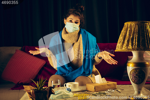 Image of Woman wrapped in a plaid wearing face mask trying to protect from somebody\'s sick