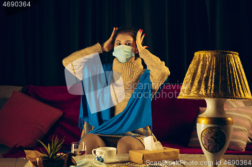 Image of Woman wrapped in a plaid wearing face mask trying to protect from somebody\'s sick