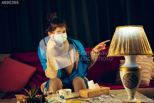 Image of Woman wrapped in a plaid wearing face mask trying to protect from somebody\'s sick